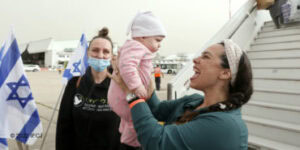 Yael Eckstein smiling at a baby who just made Aliyah