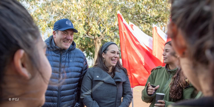 Rabbi Yechiel Eckstein and Yael Eckstein smiling and greeting a crowd.