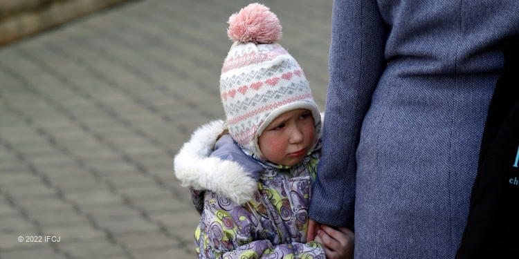 Ukrainian refugee in Moldova, a toddler holding her mother hand