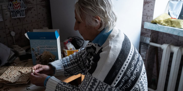 Larisa Opens a box of Matzah for Passover, provided by The Fellowship
