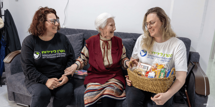 Elderly woman sits down with Fellowship volunteers.