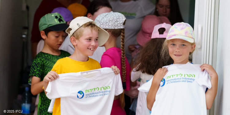 Children hold up Fellowship t-shirts