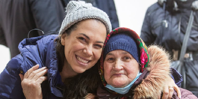 Yael Eckstein sitting next to an elderly woman smiling.