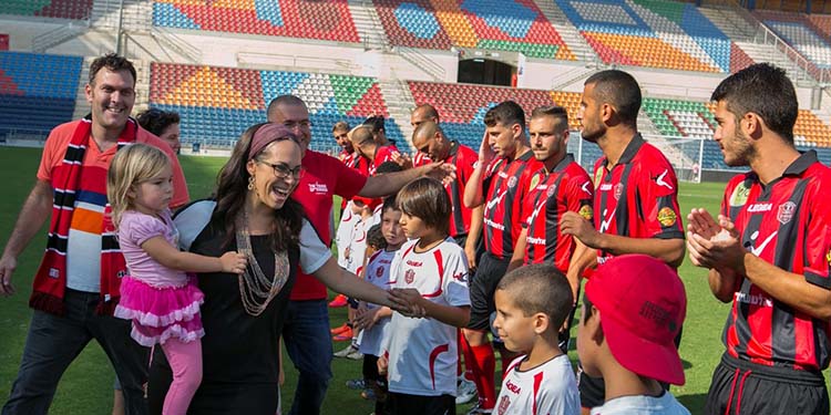 Yael with kids and soccer team